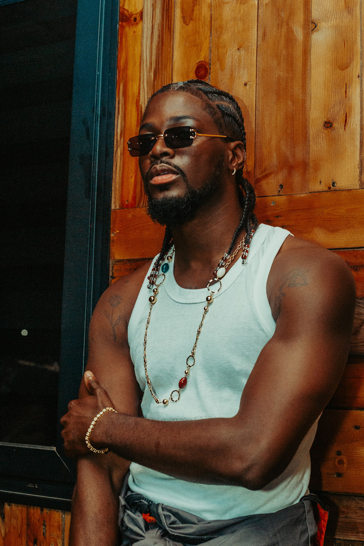 Elikem wearing sunglasses in a warm, wood-panelled setting